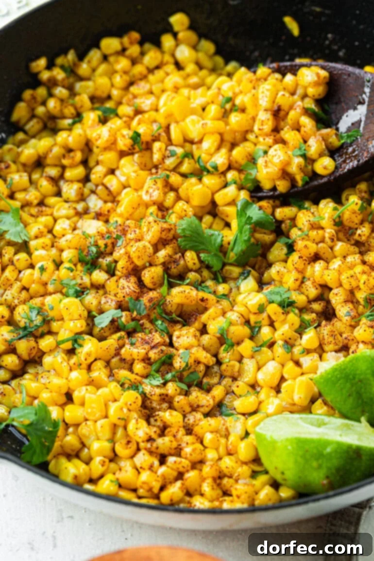 Quick Honey Lime Skillet Corn 4 A serving spoon scooping honey butter skillet corn from the pan, with fresh chopped cilantro sprinkled on top, ready to be served.