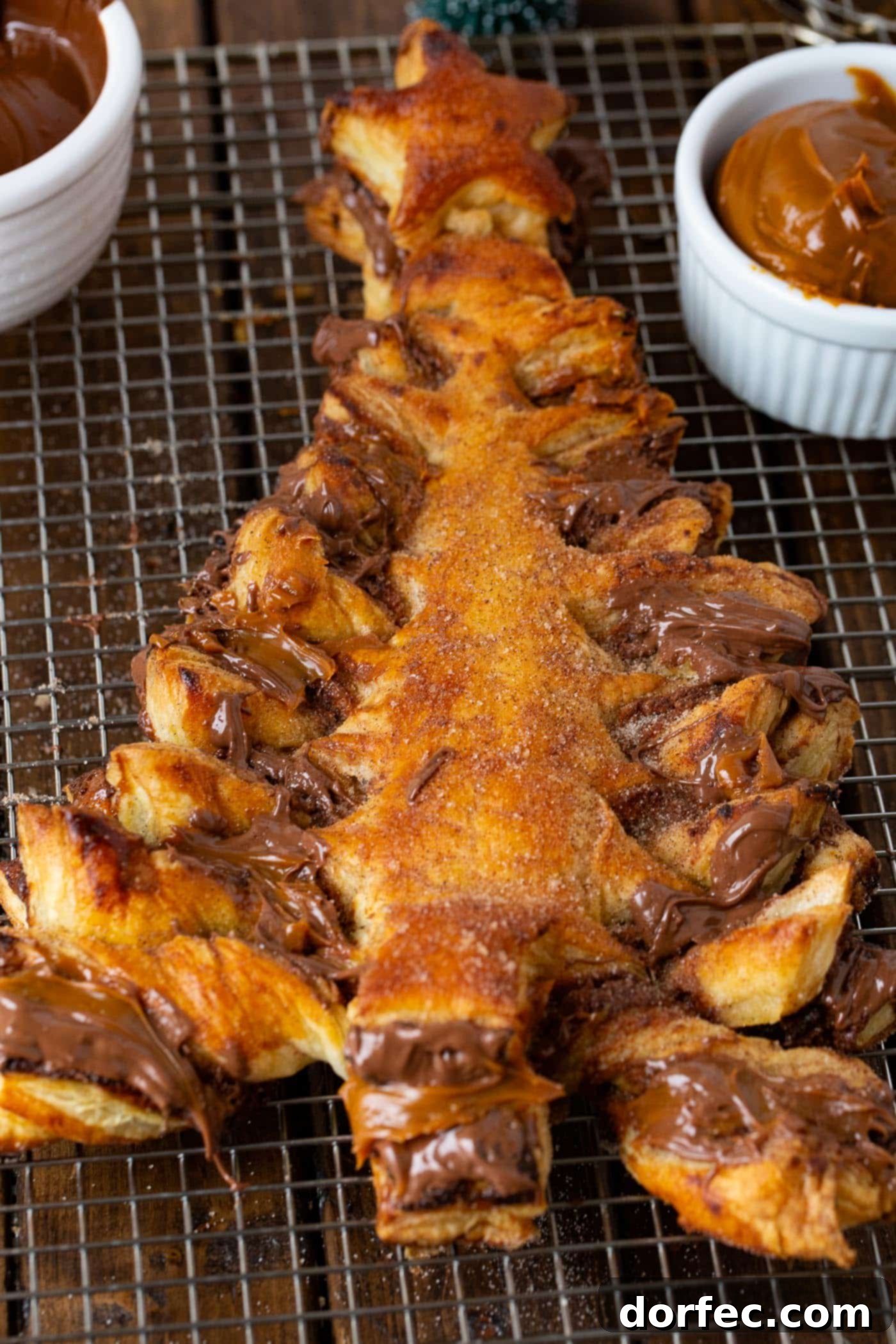 A photo of a perfectly baked, golden Nutella Dulce de Leche Puff Pastry Christmas Tree sitting on a cooling rack.