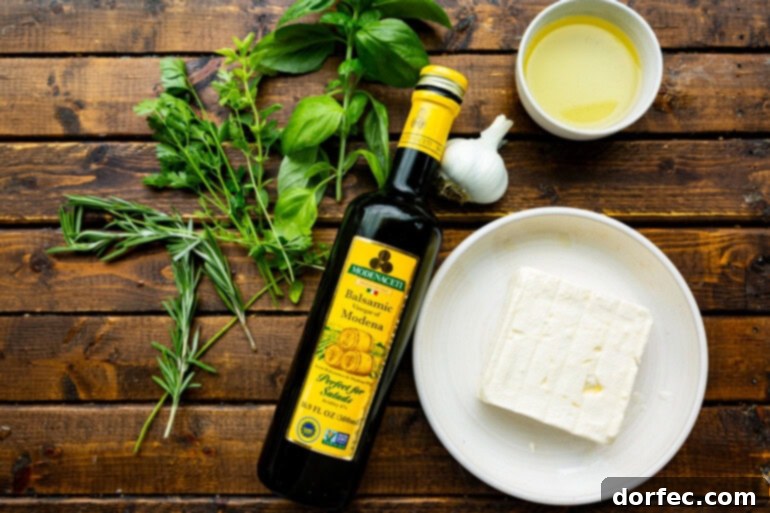 A perfectly crunchy crostini being dipped into a luscious block of feta cheese, which is glistening with aromatic herby olive oil, ready for a delightful bite.