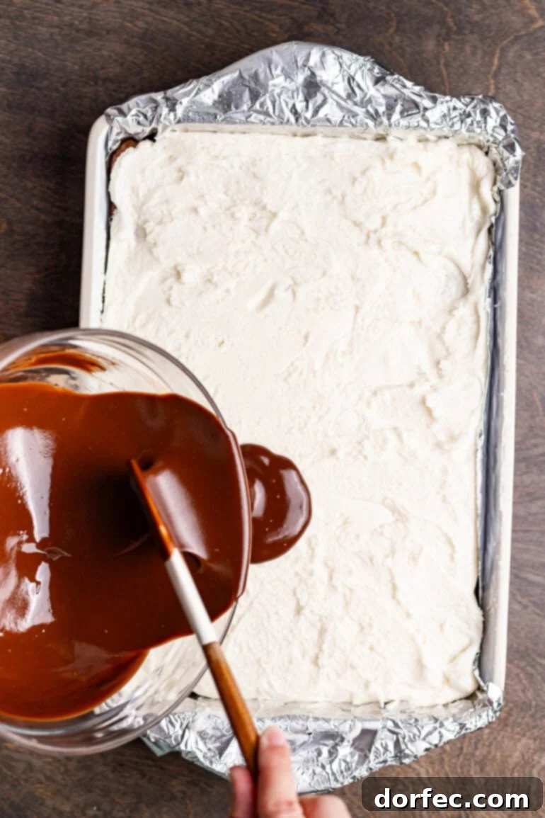 Placing the rolled peppermint layer on top of baked brownies.