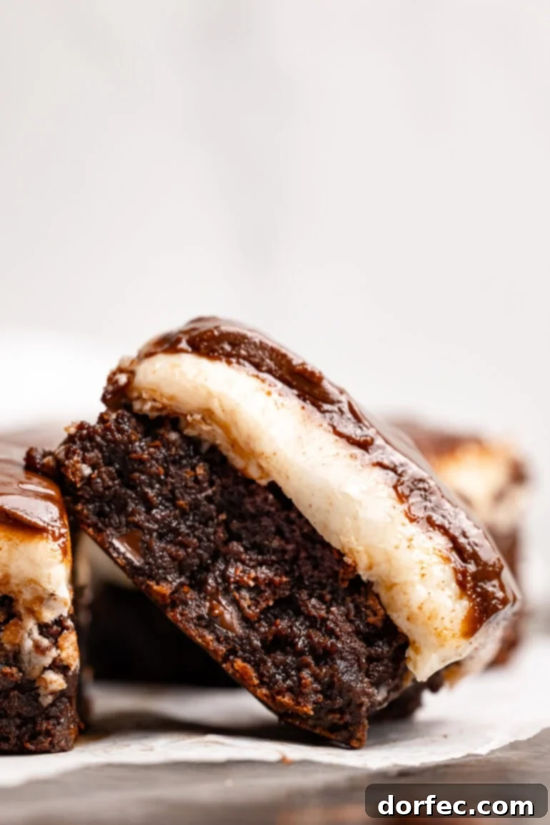 A single peppermint patty brownie tilted on its side, showing the distinct creamy white peppermint layer and the thin, glossy chocolate glaze on top of the fudgy brownie.