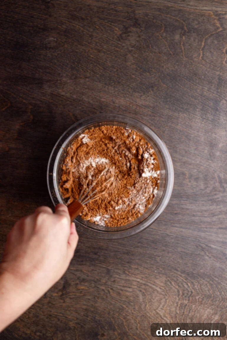 Whisking dry brownie ingredients in a separate bowl.