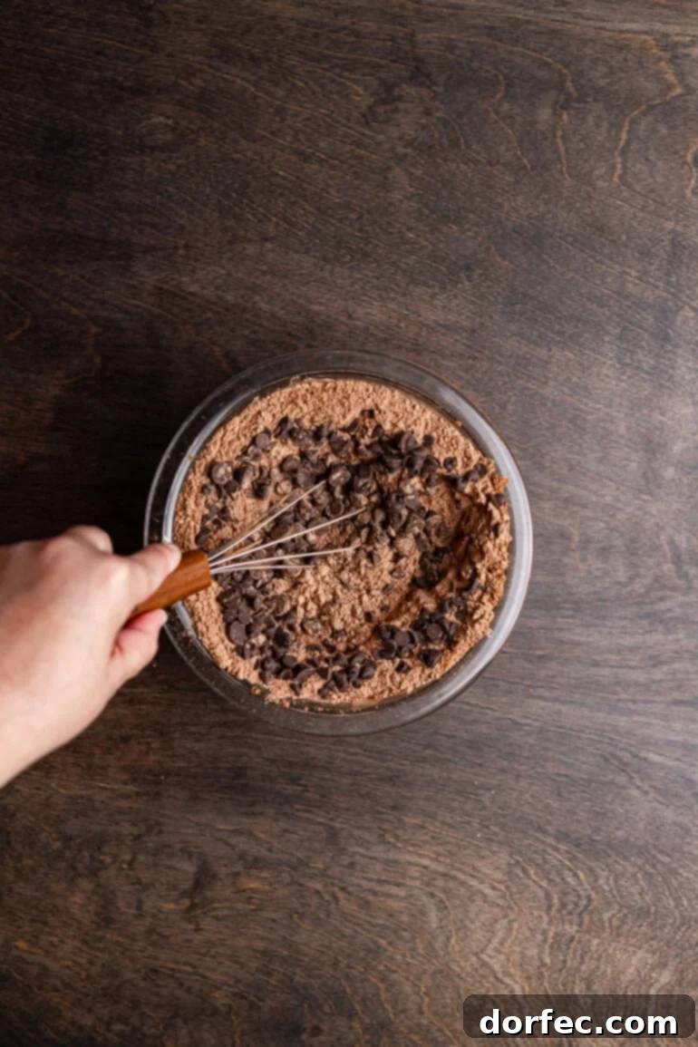 Folding chocolate chips into the dry brownie ingredients.