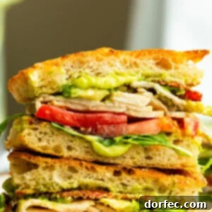 A cross-section view of a stacked Turkey Bacon Avocado Sandwich, highlighting all its flavorful layers
