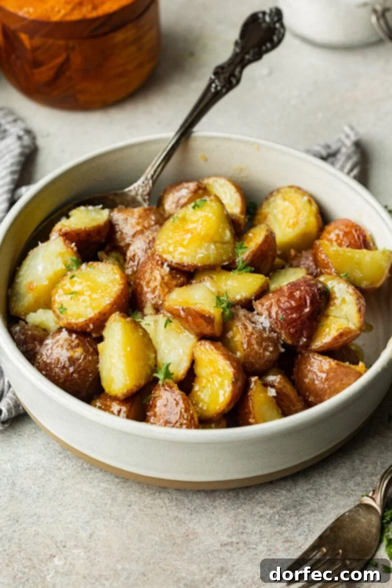 Perfectly Roasted Red Potatoes 2 White bowl filled with golden red potatoes, their crispy skin and soft centers making them look irresistible, garnished with fresh herbs.