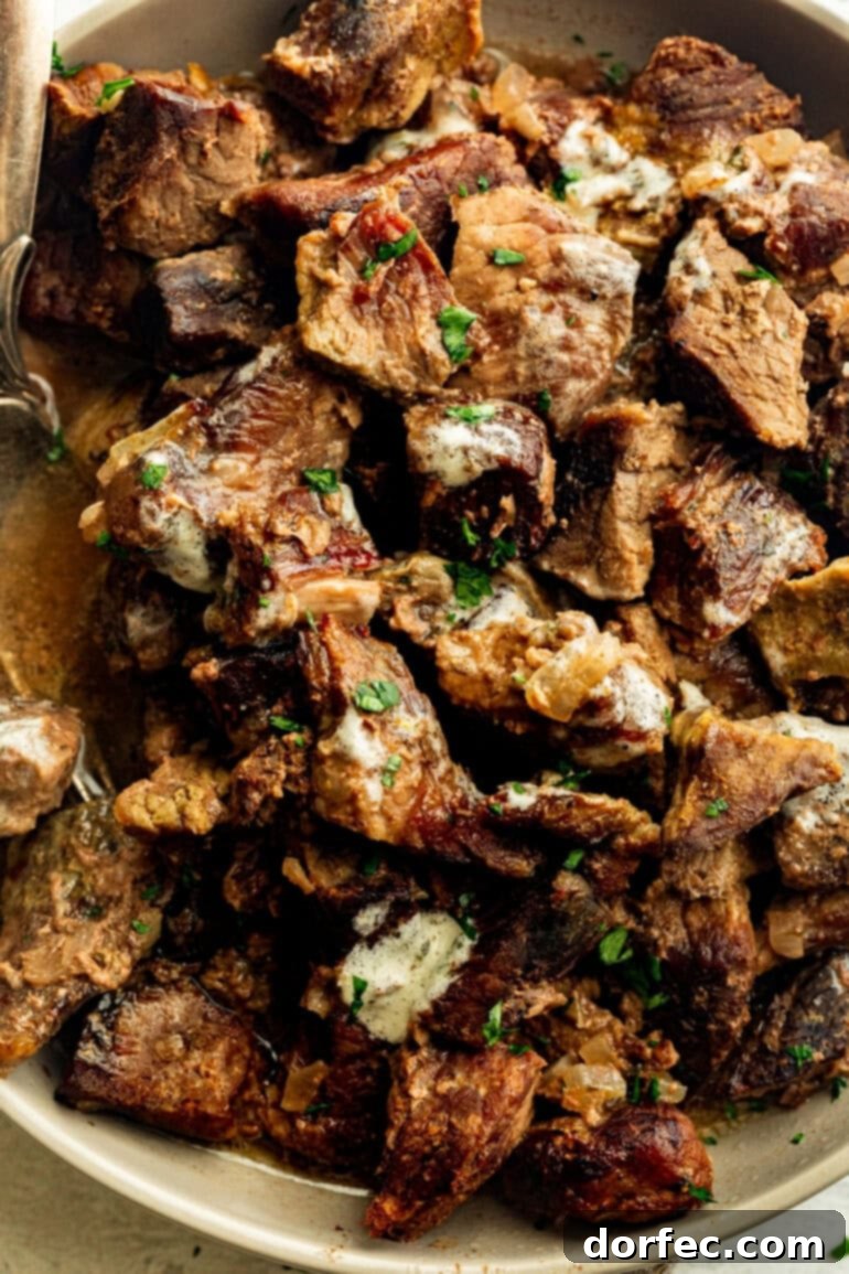 Effortless Garlic Butter Slow Cooker Steak Bites 3 A vibrant close-up shot of tender, juicy steak bites nestled in a large serving bowl, glistening with garlic butter and ready to be enjoyed.