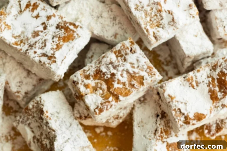 A delightful array of Chubby Hubby Peanut Butter Bars, generously coated in powdered sugar, arranged on rustic brown parchment paper.