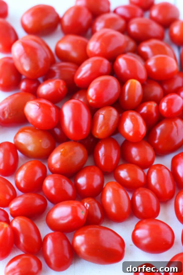 A close-up shot of a pile of fresh, ripe grape tomatoes, ready for cooking.