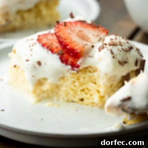 Tres Leches Cake The Creamy Three Milk Delight 7 A slice of Tres Leches Cake with a bite removed, showing the moist interior, topped with whipped cream, strawberries, and chocolate shavings