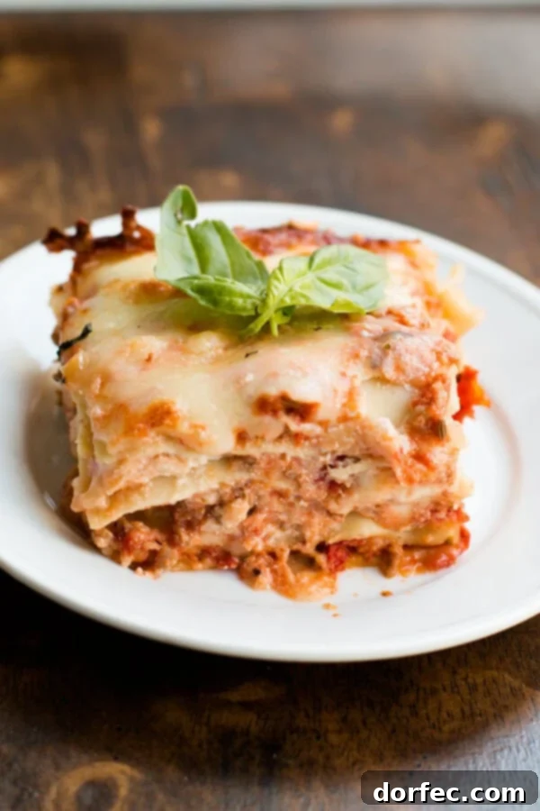 Layers of meat sauce, noodles, and cheese in a homemade sweet cheddar lasagna