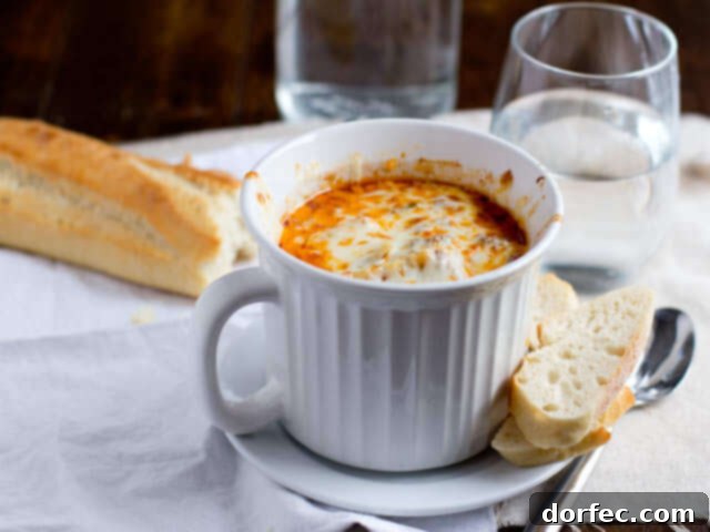 A bowl of hearty lasagna soup with melted cheese on top, perfect for a comforting meal