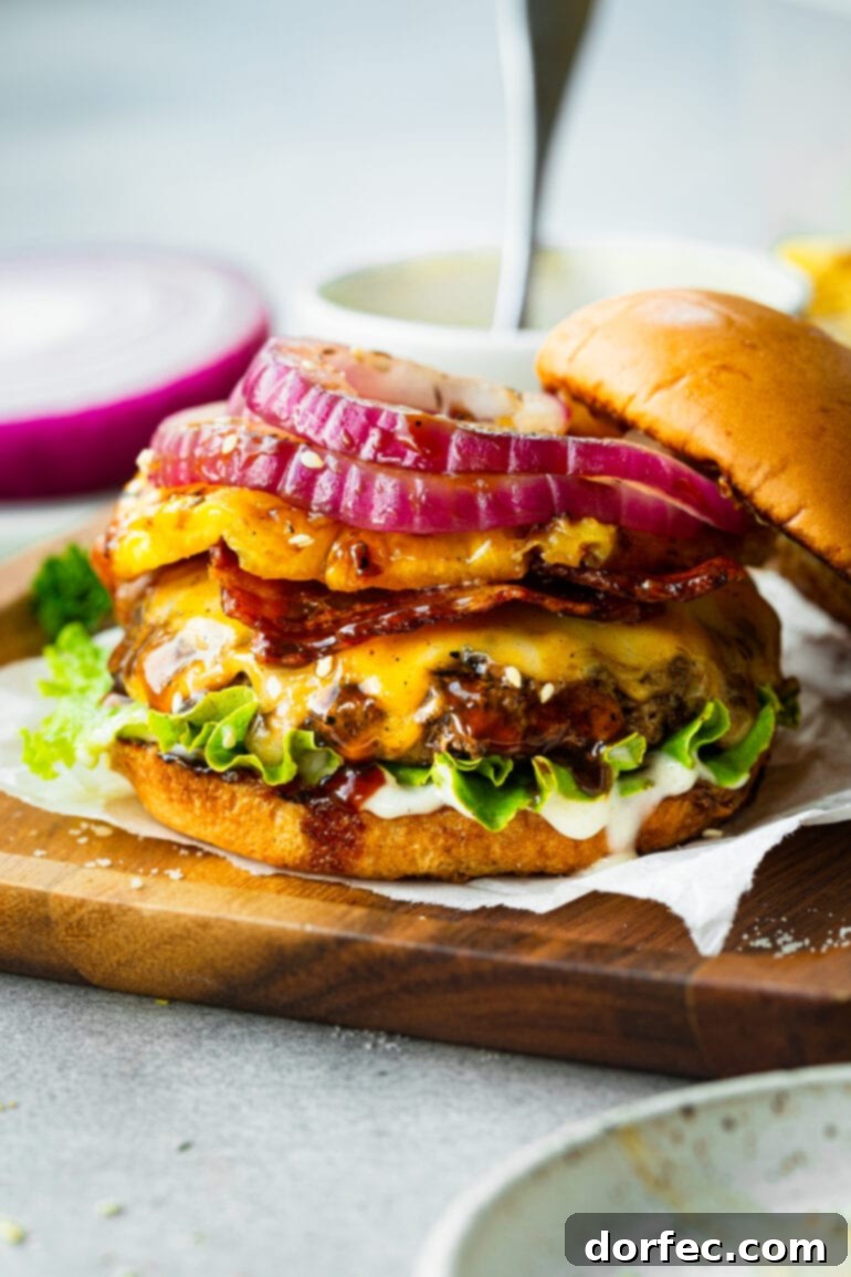 A perfectly grilled Teriyaki Pina Colada Burger, featuring a juicy patty, melted cheese, crisp green lettuce, a vibrant grilled pineapple ring, and thin slices of red onion, all presented in a toasted bun.