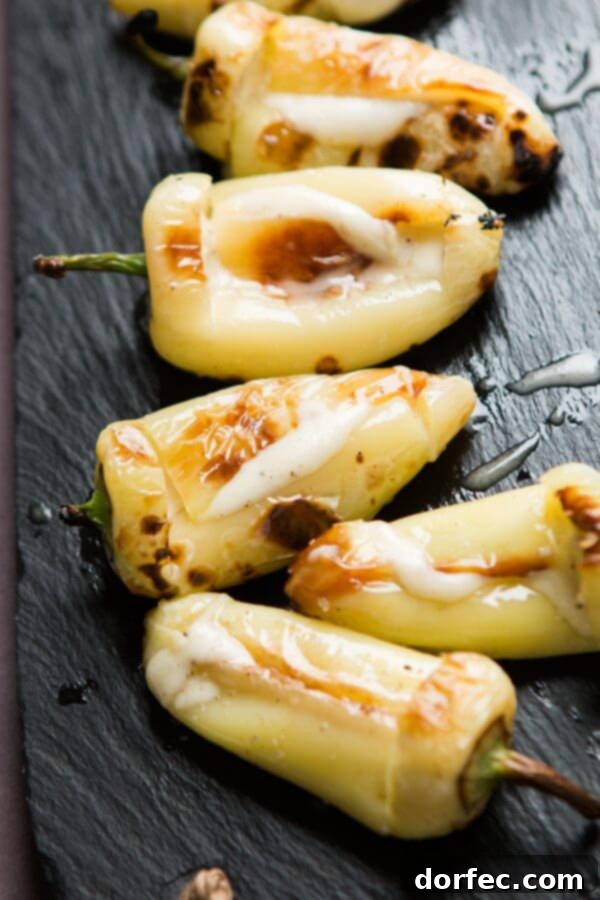 Grilled yellow peppers with melted cheese, glistening with olive oil and seasoned with fresh herbs.