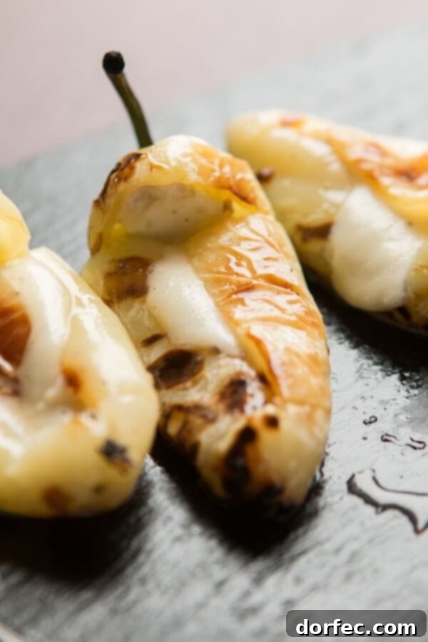 A close-up of a perfectly charred and stuffed pepper on the grill, showing its readiness for serving.