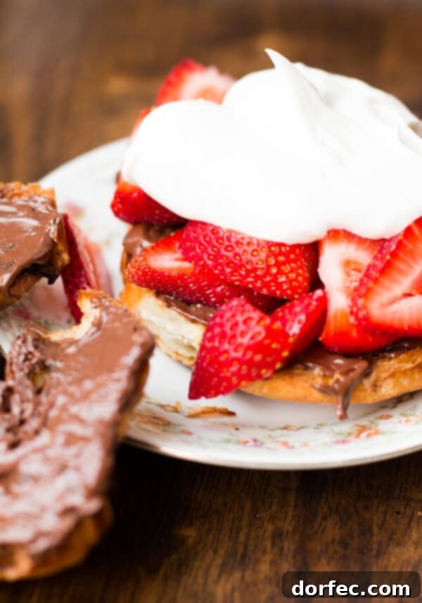 Overhead view of several grilled Nutella strawberry croissants artfully arranged on a serving board, ready to be enjoyed.