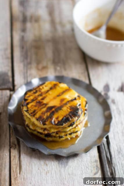 Grilled Pineapple with brown sugar butter. Perfection all summer long with only 3 ingredients! A sweet and simple side dish from OhSweetBasil.com