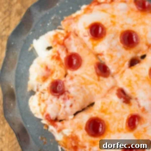A close-up of a delicious, freshly made egg white pizza with melted cheese and mini pepperonis, ready to eat.