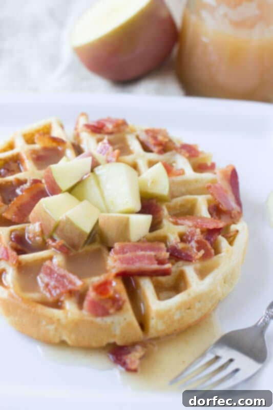 Fluffy waffles filled with sweet apples and crisp bacon, topped with the best homemade apple cider syrup for an unforgettable breakfast.