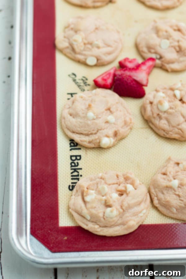Family favorite Strawberry Pudding Cookies A child's hand reaching for a fresh Strawberries and Cream Pudding Cookie, emphasizing family appeal