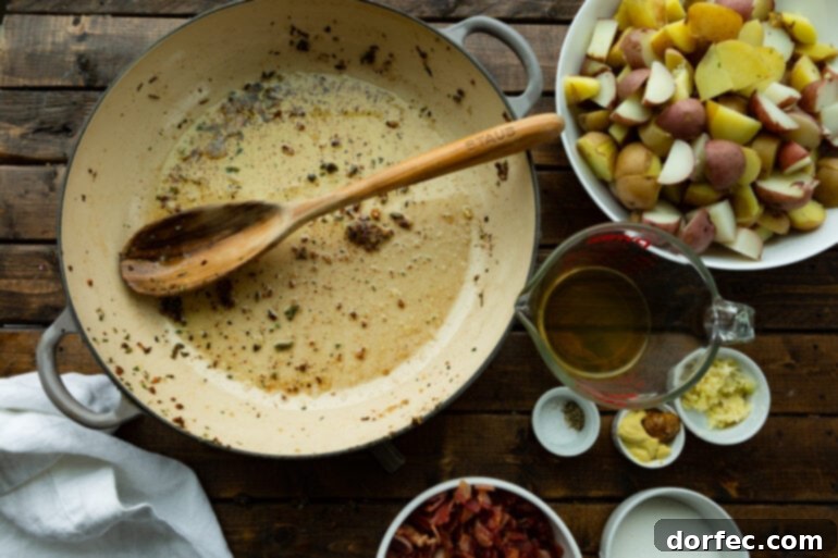 a photo of a dutch oven that has been used to cook bacon that is empty and the bacon crumbles are on the side.