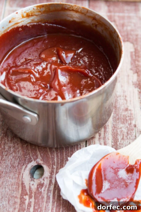 A close-up shot of the homemade BBQ sauce simmering in a saucepan, showing its thick, rich texture.