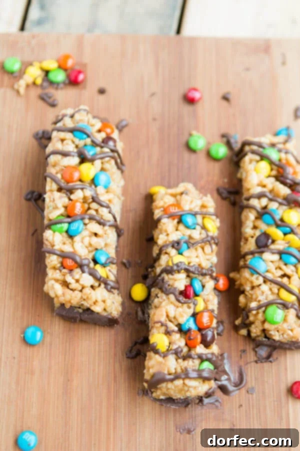 Homemade Peanut Butter M&M Kudos Bars 4 A stack of Peanut Butter M&M Kudos Copycat bars, with a visible layer of melted chocolate at the bottom.