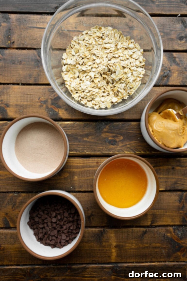 A beautifully arranged photo showcasing all the individual ingredients for oatmeal energy bites in separate small bowls: rolled oats, creamy peanut butter, golden honey, chocolate chips, and fluffy puffed brown rice.