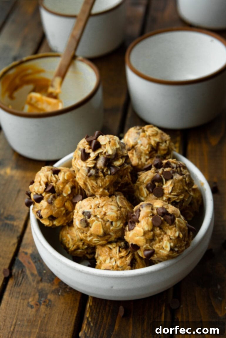 An appetizing overhead shot of a large bowl generously filled with glistening protein chocolate energy bites, each studded with an abundance of visible chocolate chips, highlighting their rich texture.