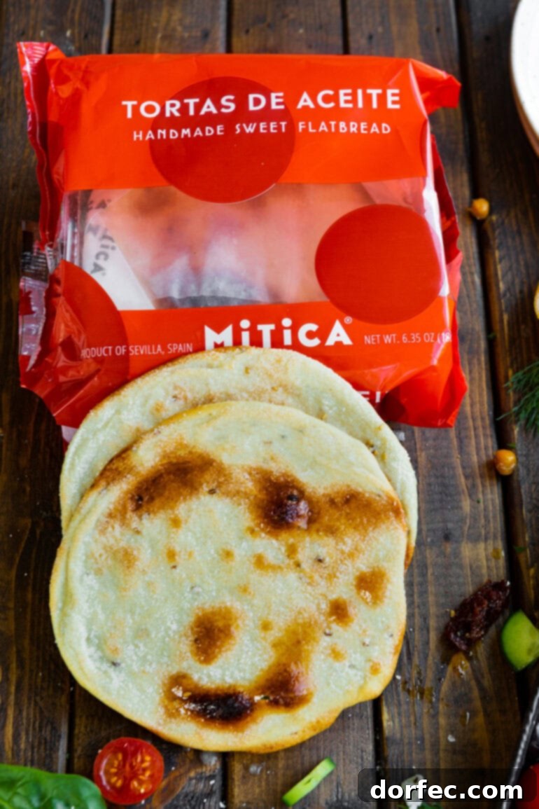 A photo of an empty package for Spanish flatbread with two pieces of the flatbread sitting on top of it, indicating a unique tostada base.