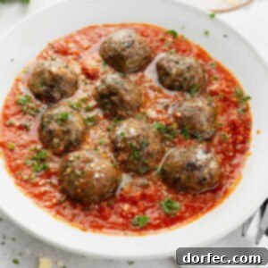 A delicious serving of classic spaghetti and meatballs, with the meatballs generously coated in a rich tomato sauce.