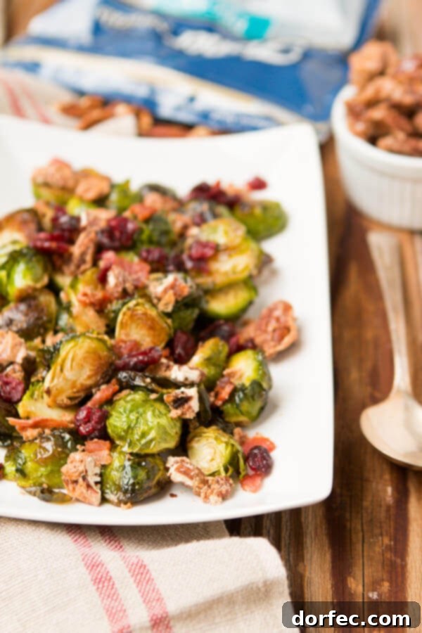 A festive holiday side dish featuring a mix of pan-roasted Brussels sprouts, sweet candied pecans, and savory bacon, perfect for a Thanksgiving or Christmas meal.