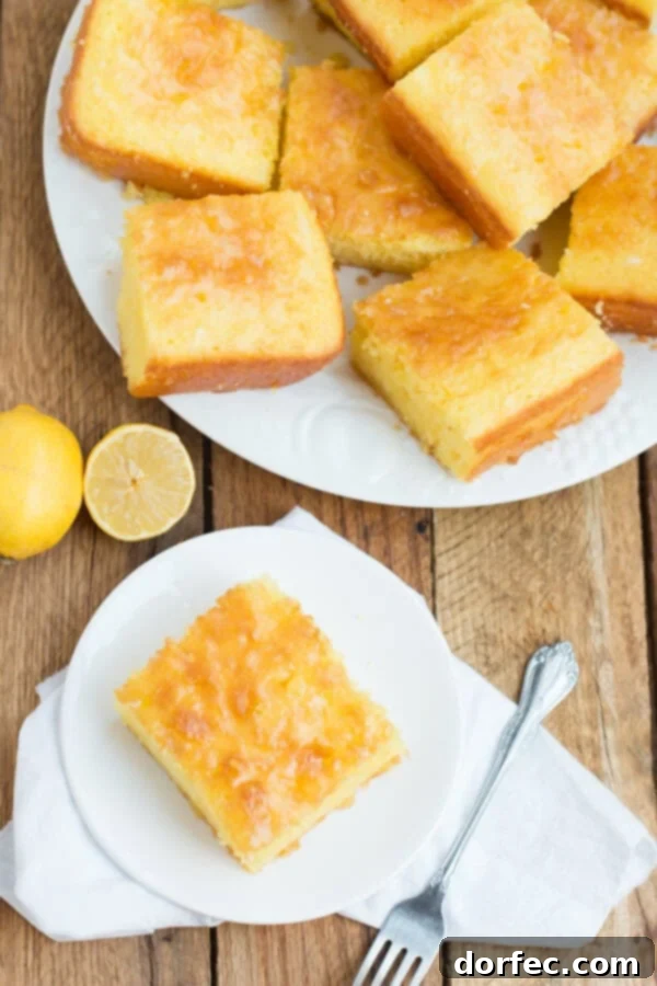 Multiple slices of Lemon Jello Cake arranged on a large white plate, with an additional slice on a small plate with a napkin.