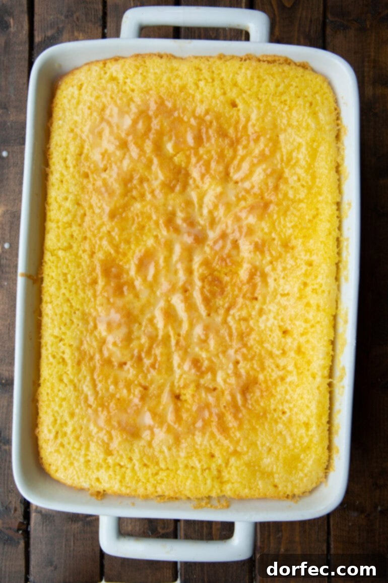 A photo of a whole 9x13 lemon cake in a elegant white ceramic baking dish, perfectly baked and ready for glazing.