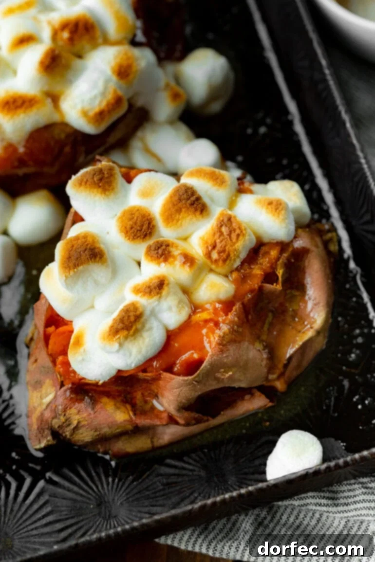 The Ultimate Texas Roadhouse Loaded Sweet Potato at Home 2 A photo of a baked sweet potato topped with butter and toasted mini marshmallows, ready to be enjoyed.