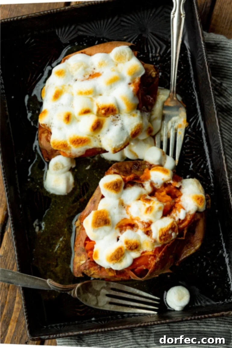 The Ultimate Texas Roadhouse Loaded Sweet Potato at Home 3 A photo of two beautifully baked sweet potatoes, generously topped with toasted mini marshmallows, showcasing their golden-brown perfection.