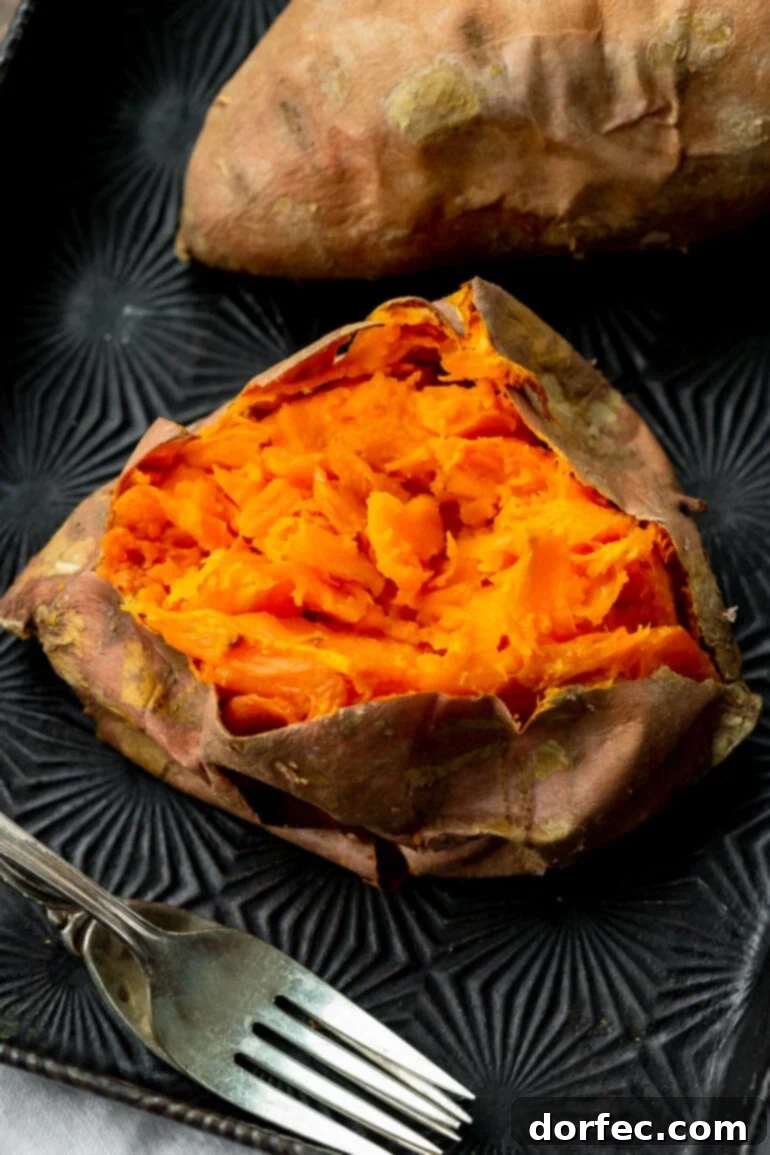 The Ultimate Texas Roadhouse Loaded Sweet Potato at Home 4 A photo of a baked sweet potato that has been sliced open and mashed inside, revealing its tender, fluffy texture.