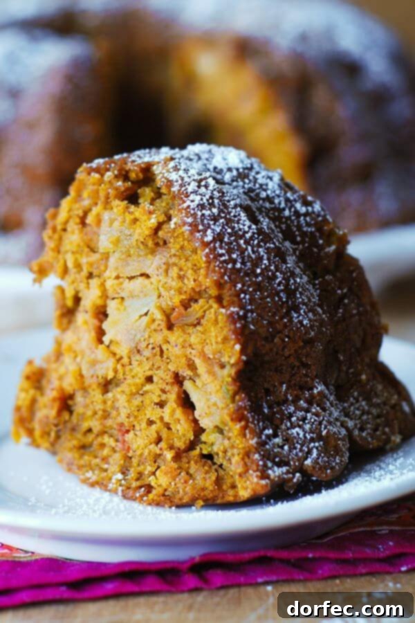 Close-up of a slice of Apple Pumpkin Spice Bundt Cake, revealing chunks of real apple and a moist texture.