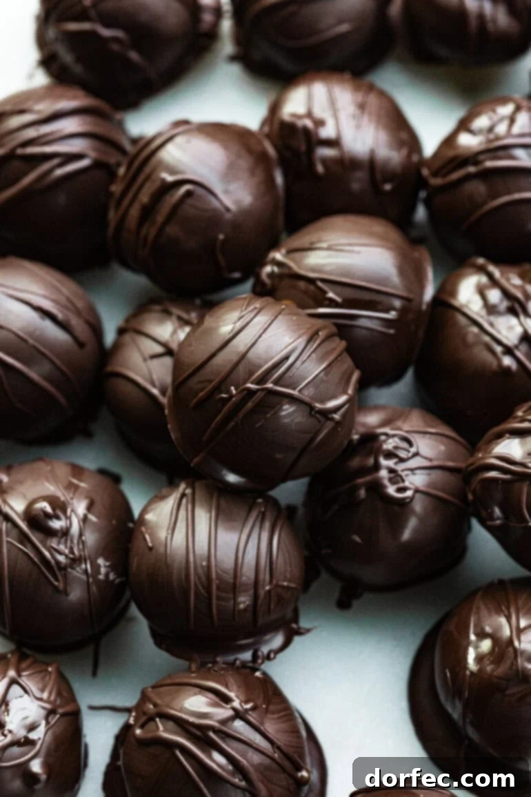 A close-up photo of several peanut butter truffles generously dipped in rich dark chocolate.