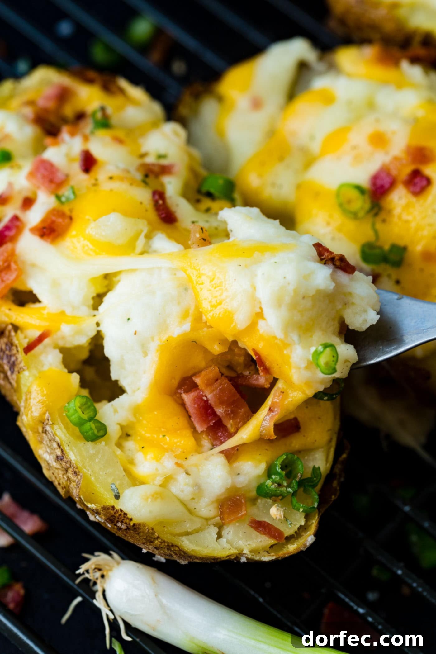 A cooling rack filled with loaded twice baked potatoes, highlighting their cheesy, bacon-topped goodness ready to be served