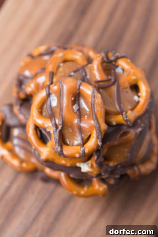 A child's hands carefully placing pretzels on melted chocolate, demonstrating the ease of making salted caramel pretzel snaps for all ages.