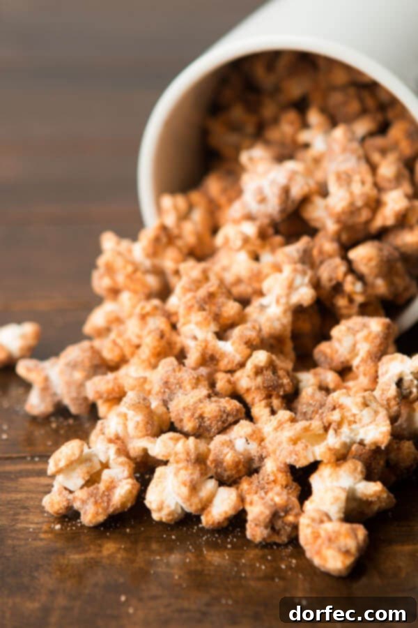 Hand reaching for a handful of sweet churro popcorn