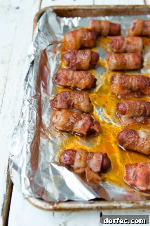 Easy Make-Ahead Bacon-Wrapped Little Smokies for Any Occasion Platter of perfectly baked bacon-wrapped little smokies, glistening with a sweet and savory glaze, ready for serving.