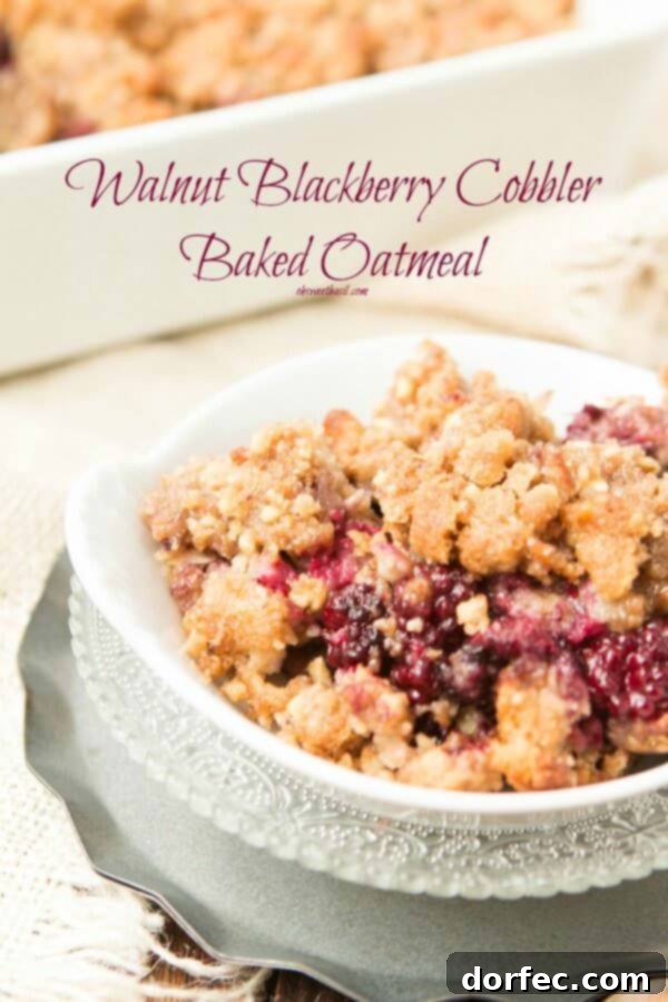 Blackberry Cobbler Baked Oatmeal - Healthy & Delicious Close-up of baked oatmeal with a spoonful missing, showing the rich blackberry filling and golden walnut crumble. A perfect dessert-for-breakfast option.