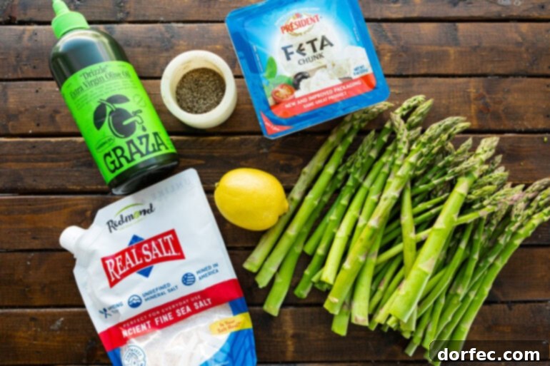 Zesty 5-Minute Lemon Feta Grilled Asparagus 4 A beautifully composed photo showcasing all the fresh ingredients needed for grilled lemon feta asparagus, including vibrant asparagus spears, crumbled feta cheese, a whole lemon, salt, pepper, and a bottle of olive oil.