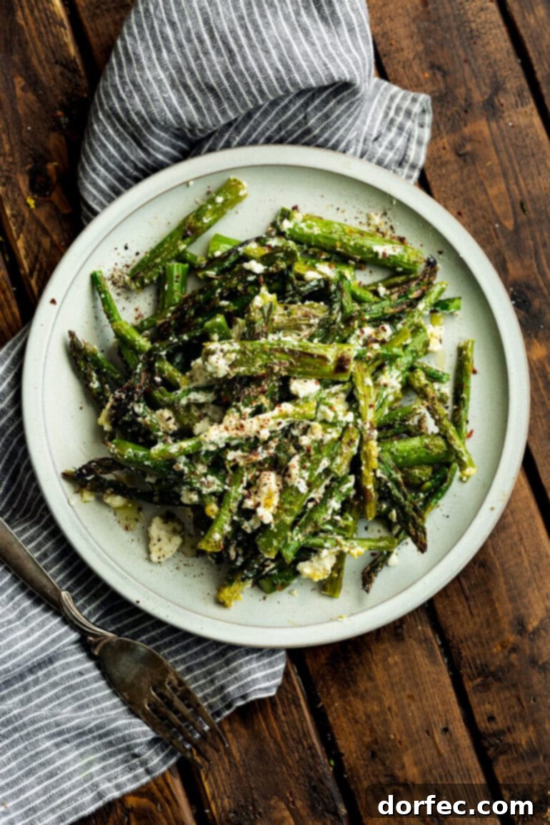 Zesty 5-Minute Lemon Feta Grilled Asparagus 5 A stunning overhead shot of charred and perfectly grilled asparagus, seasoned with salt and pepper, and generously tossed with crumbled feta cheese.