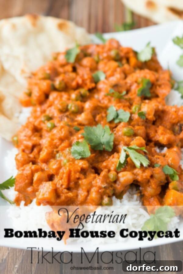Close-up of the rich, orange-hued creamy sauce of the vegetarian Tikka Masala, showcasing the tender sweet potatoes and chickpeas.