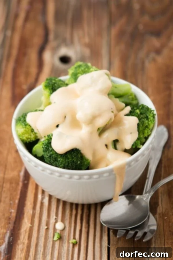5-Ingredient Creamy Broccoli and Cheese 3 Close-up of freshly steamed broccoli generously coated in a rich, smooth homemade cheese sauce.