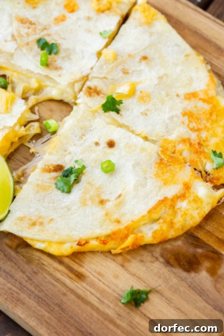 A perfectly cooked quarter of a cheese quesadilla with melted cheese oozing out, highlighting the golden-brown tortilla.