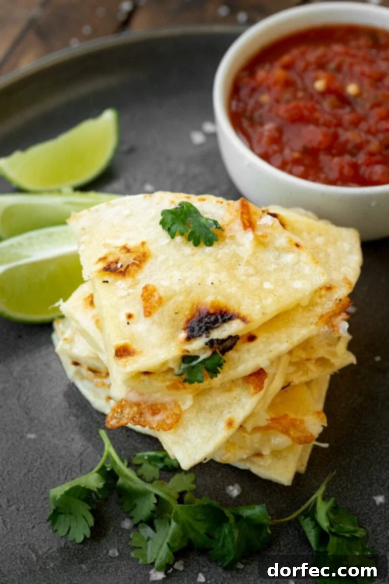 A stack of triangular pieces of cheese quesadillas made with corn tortillas, showcasing their golden crust.