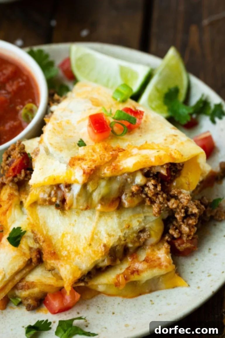 Cheesy ground beef quesadillas, expertly cut into quarters and stacked, showcasing the rich filling.